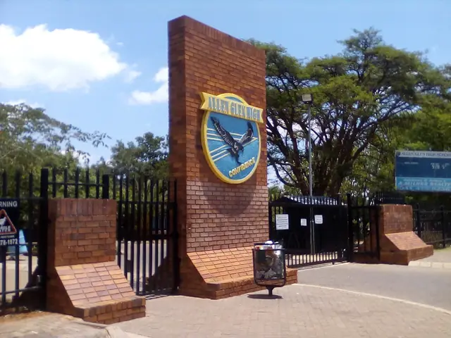 Allen Glen High School entrance gate with the school crest on a brick pillar