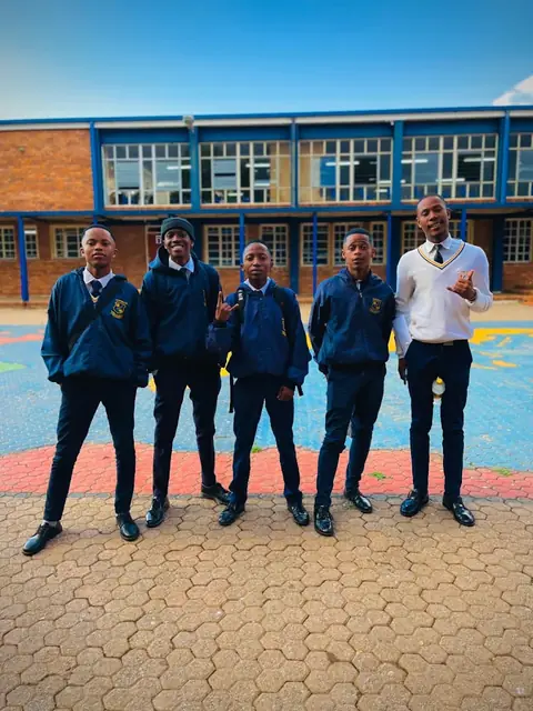 Glenbrack High School learners in navy uniform outside a classroom block