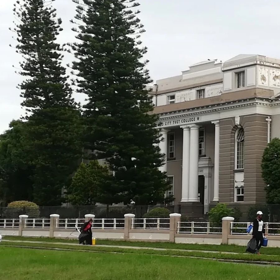Buffalo City TVET College building with white columns and staff walking across the front lawn, East London