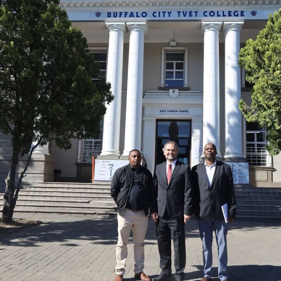 Three men in suits standing at the columned entrance of Buffalo City TVET College East London Campus