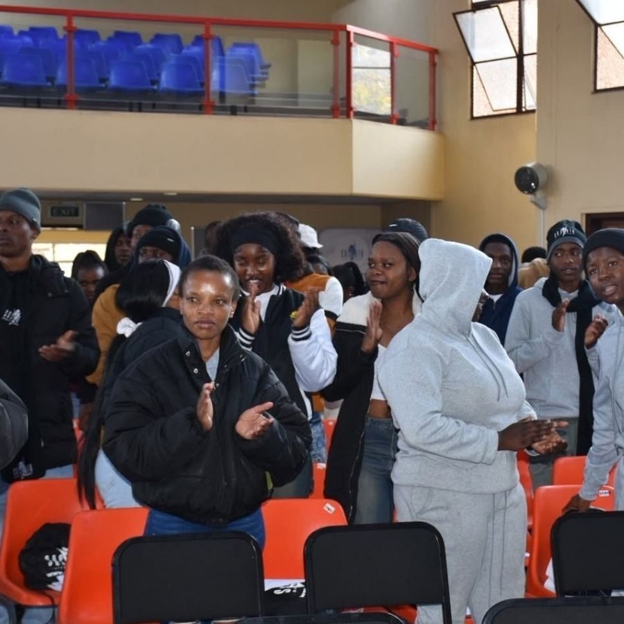 Central Johannesburg College students standing and clapping in a hall during a college event