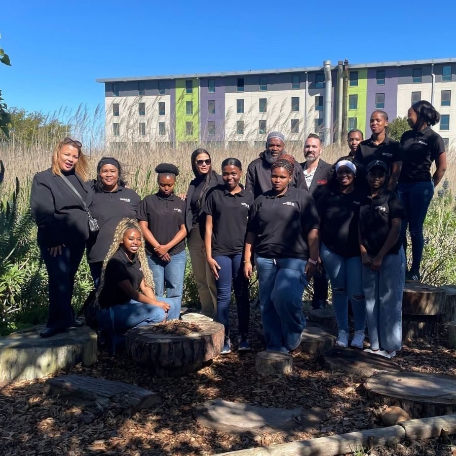 Group Photo Outside Student Residence College of Cape Town staff and students in black polo shirts posing outdoors in front of a student residence building