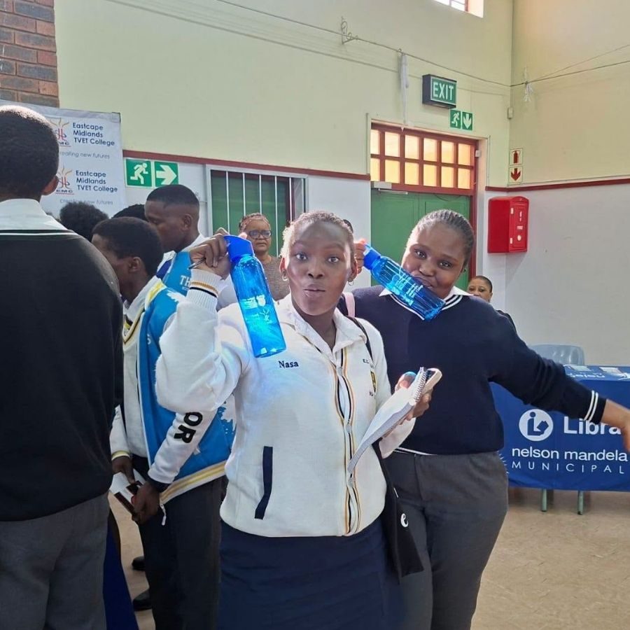 Students Enjoying a Community Outreach Event Eastcape Midlands TVET College students playfully posing with water bottles at a community library outreach event