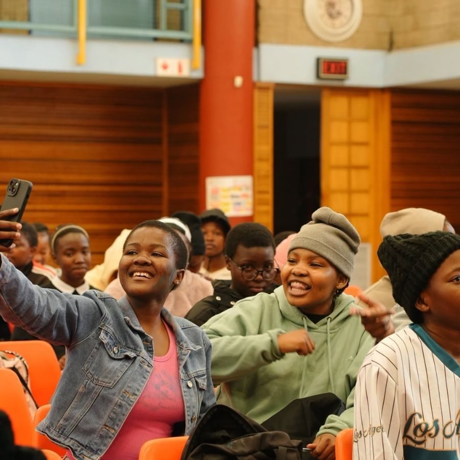 Ekurhuleni East TVET College students smiling and taking a selfie while seated in a college hall