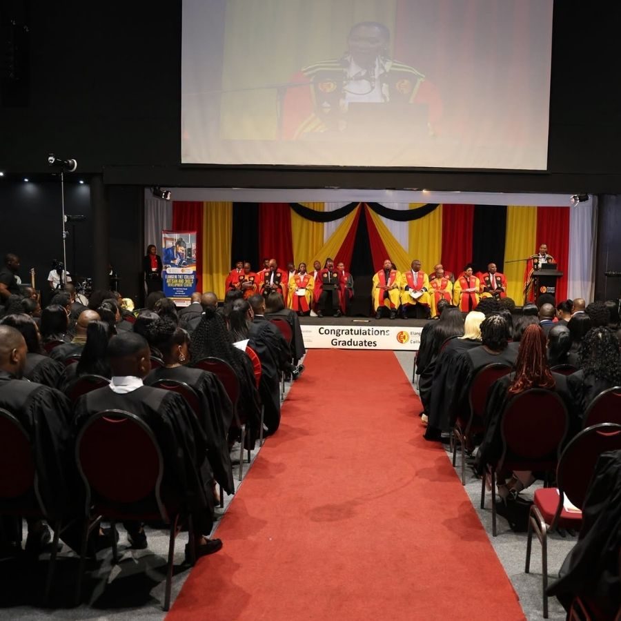 Elangeni TVET College Graduation Ceremony Hall Wide view of the Elangeni TVET College graduation hall with graduates seated along a red carpet and officials on stage.