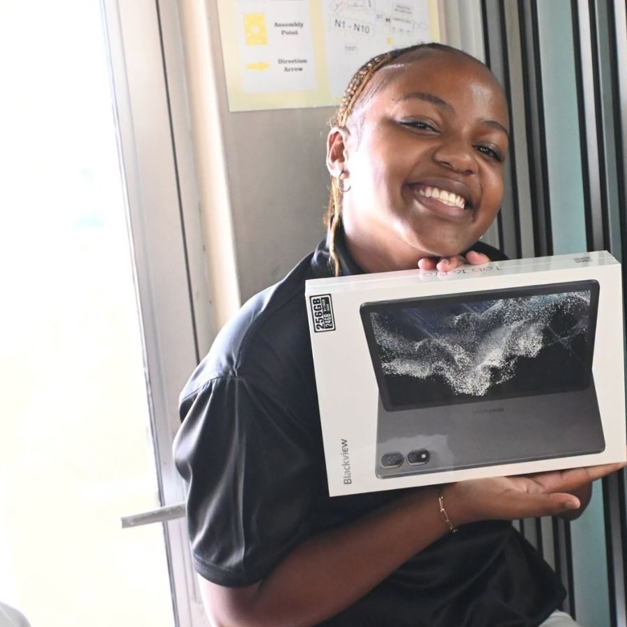 Esayidi TVET College Student Receives Tablet Prize Smiling Esayidi TVET College student holding a boxed Blackview tablet received as a prize.