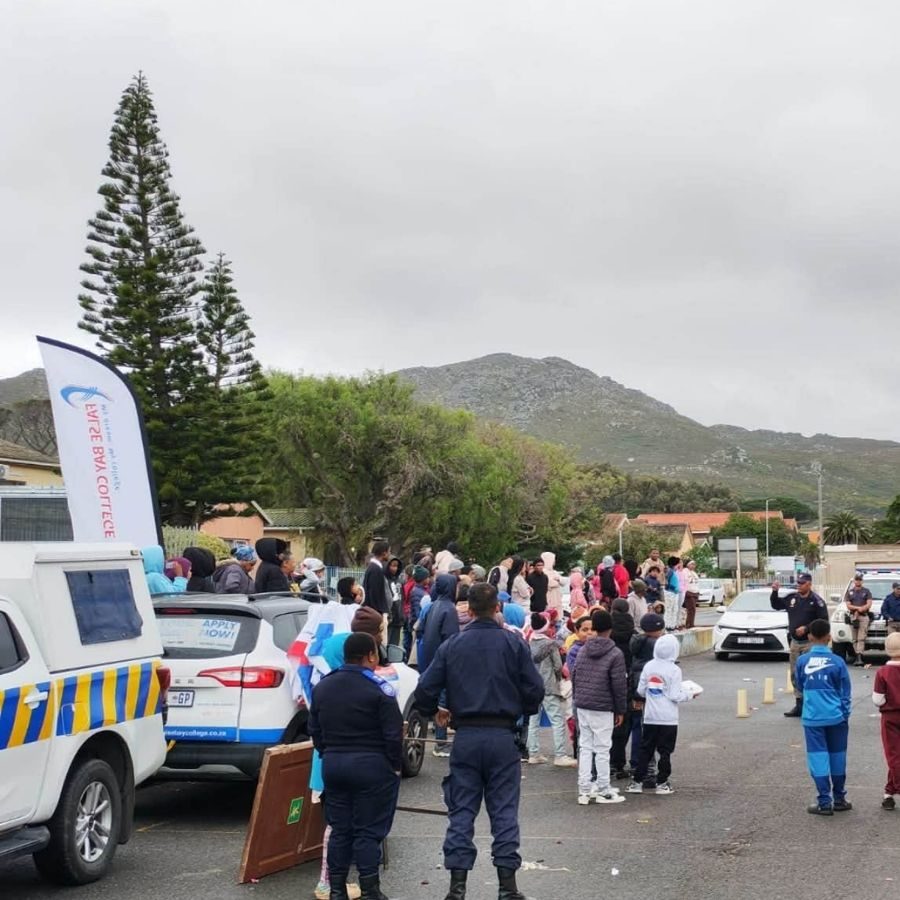 False Bay TVET College Community Outreach Event Crowd gathered outdoors near False Bay TVET College branded vehicles and police for a community outreach event.