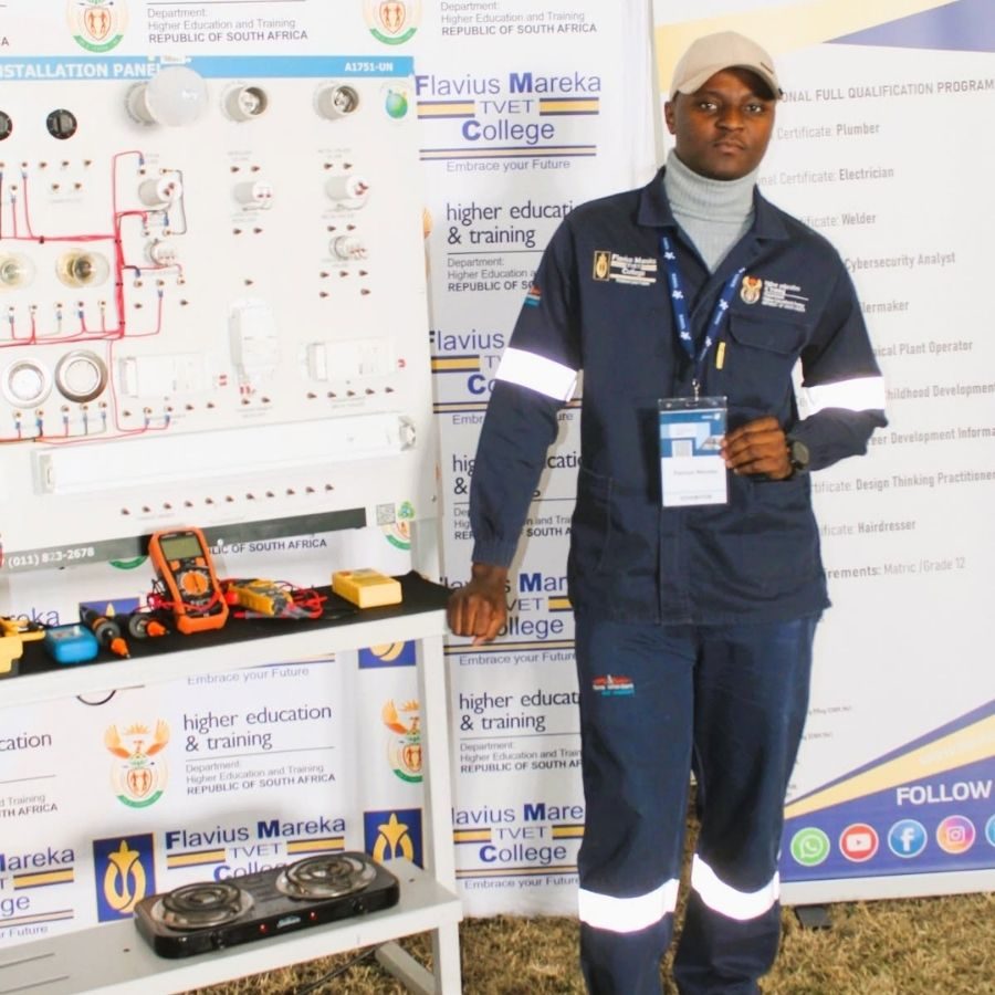 Flavius Mareka TVET College Electrical Programme Showcase Flavius Mareka TVET College student beside an electrical installation training panel and tools at a programme showcase.