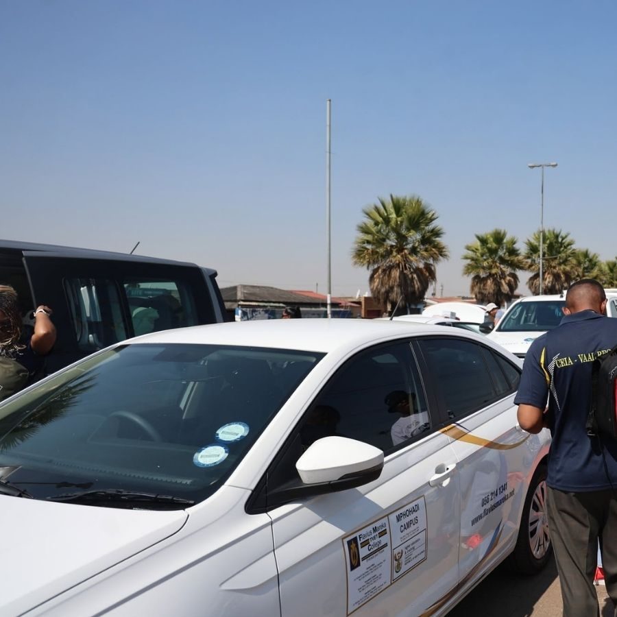 A Flavius Mareka TVET College branded vehicle is parked at a regional TVET event with palm trees behind it.