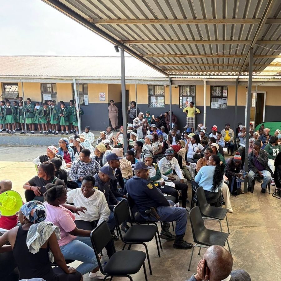 King Hintsa TVET College Community Outreach Gathering Large community crowd gathered under a shelter for a King Hintsa TVET College outreach event, with schoolchildren nearby.