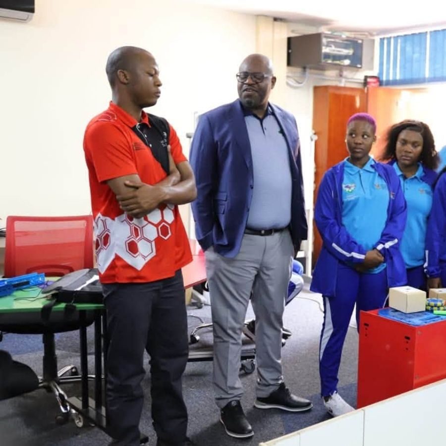 Lephalale TVET College Robotics Demonstration to Visitors Lephalale TVET College students in blue uniforms showing a robotics project to staff and a visiting official indoors