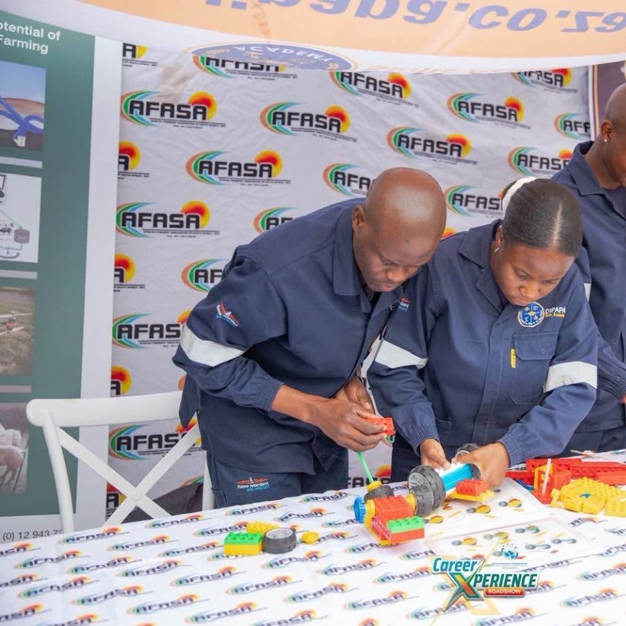 Letaba TVET College Staff at Career Xperience Roadshow Stand Letaba TVET College representatives in overalls building a model at an AFASA-branded stand during a Career Xperience Roadshow