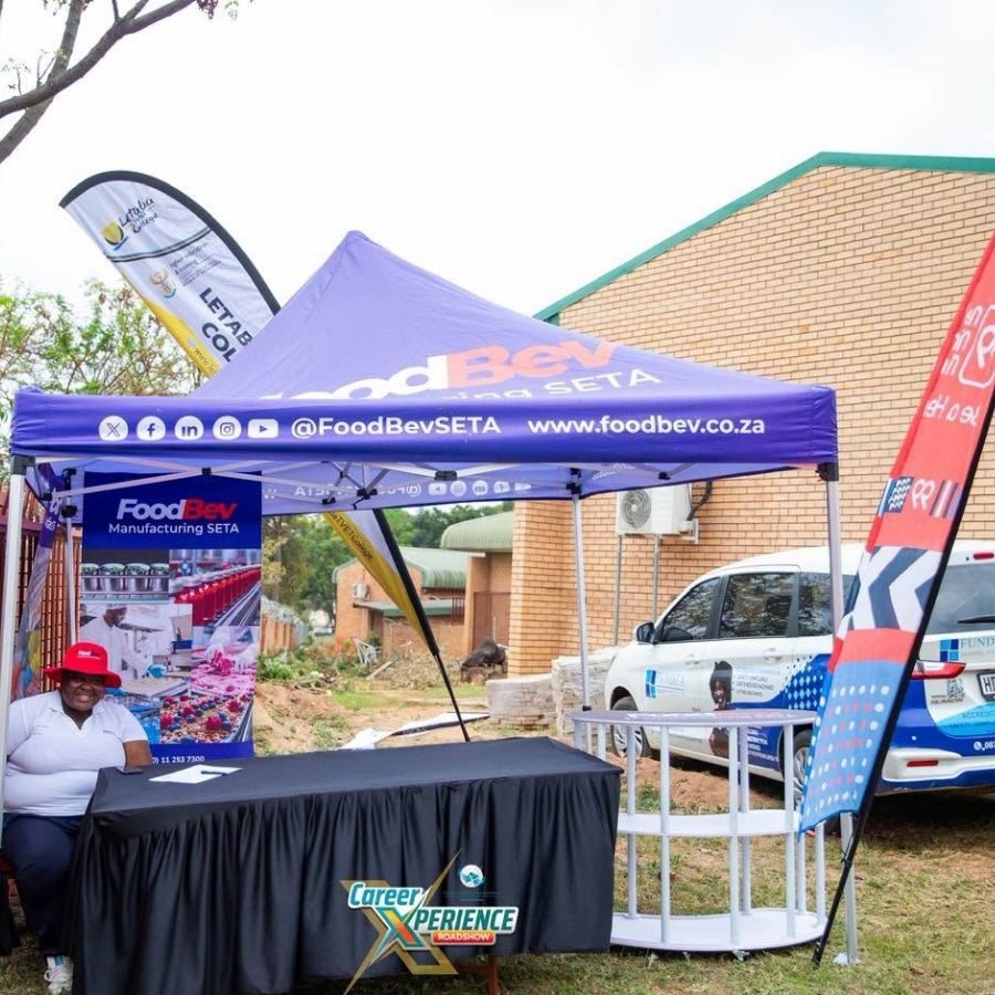 Letaba TVET College Branded Tent at Careers Roadshow Letaba TVET College flag banner beside a FoodBev Manufacturing SETA gazebo at the outdoor Career Xperience Roadshow