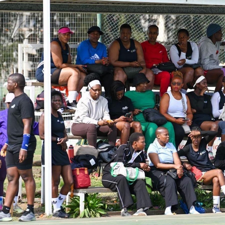 Spectators Watching a Match from the Stands at Majuba TVET College Majuba TVET College staff and students seated in tiered stands watching a sports match on the netball or hockey court