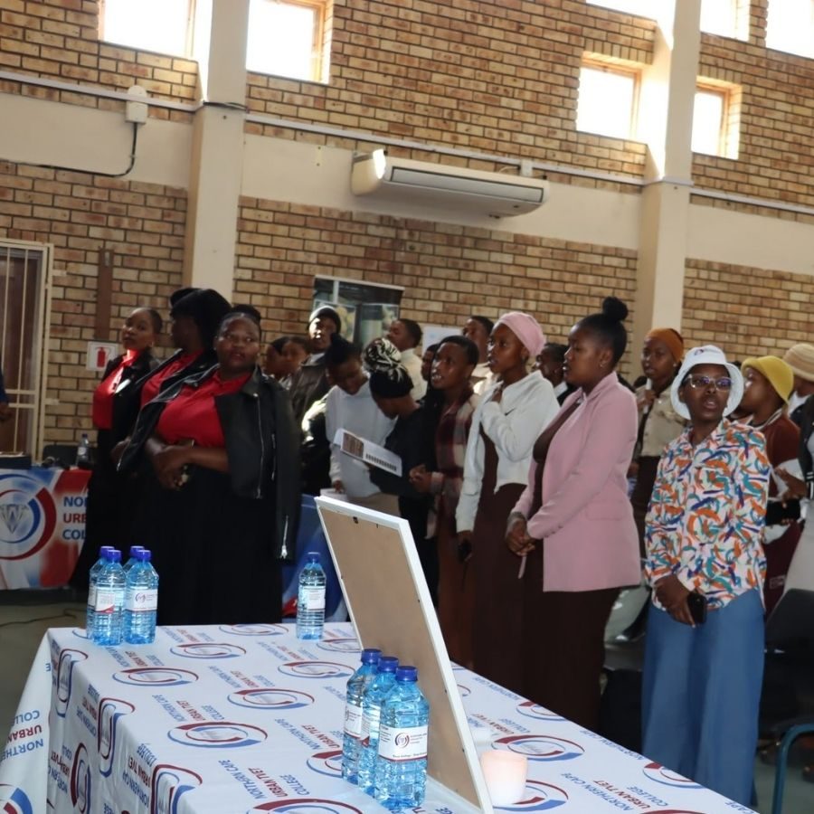 Students stand together in a hall at Northern Cape Urban TVET College during a campus gathering.