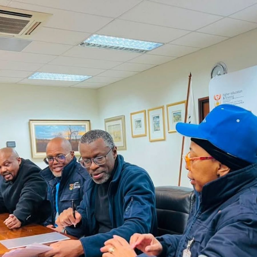 Sedibeng TVET College Management Meeting Sedibeng TVET College staff review documents together during a management meeting in a boardroom.