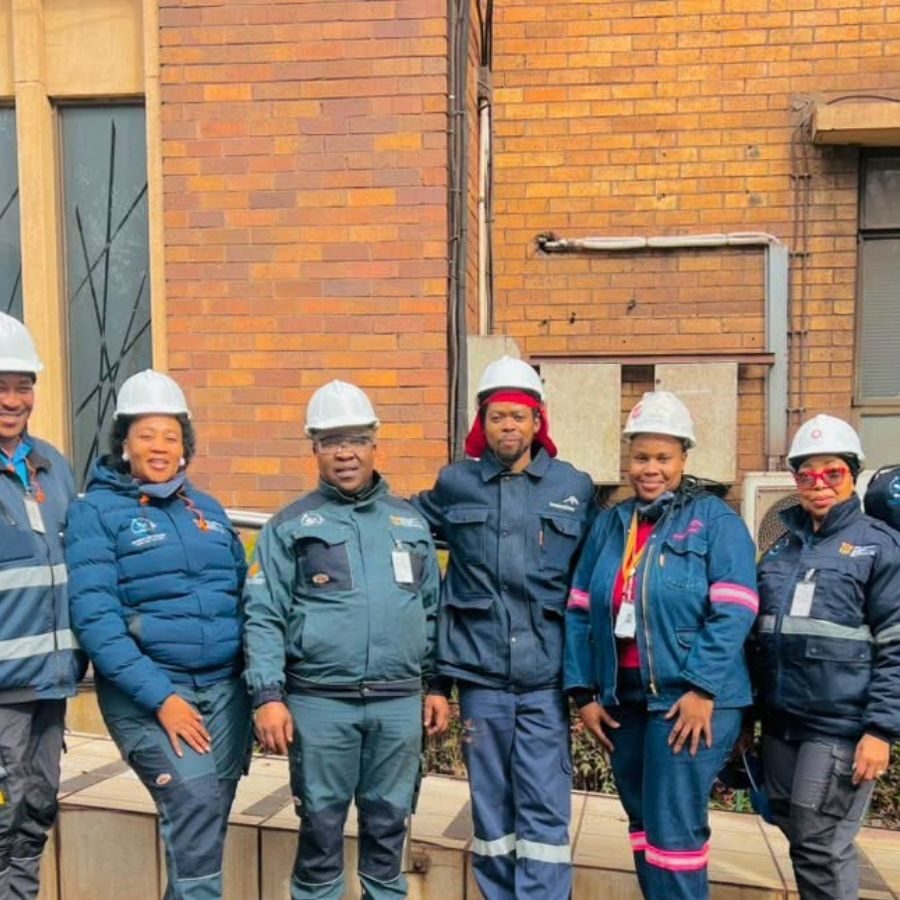 Sedibeng TVET College Site Visit in Hard Hats Sedibeng TVET College staff wearing hard hats and safety gear pose during an industrial site visit.