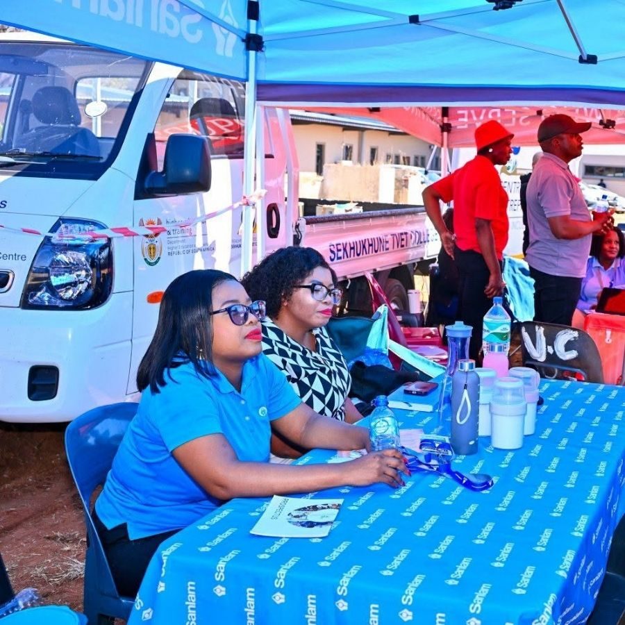 Sekhukhune TVET College Outreach Stall Staff sit at a Sekhukhune TVET College outreach stall under a tent, with the college branded truck parked behind them.