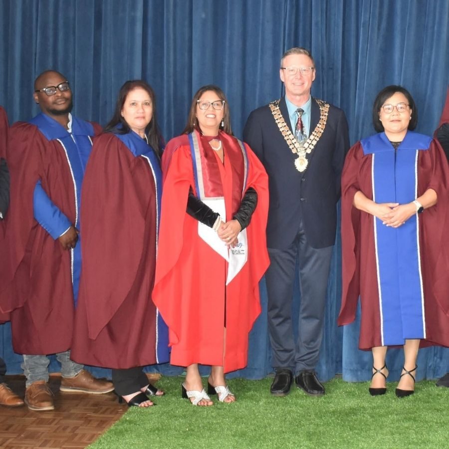 South Cape TVET College Graduation Stage Party South Cape TVET College academic staff pose on stage with a mayor wearing a chain of office at graduation.