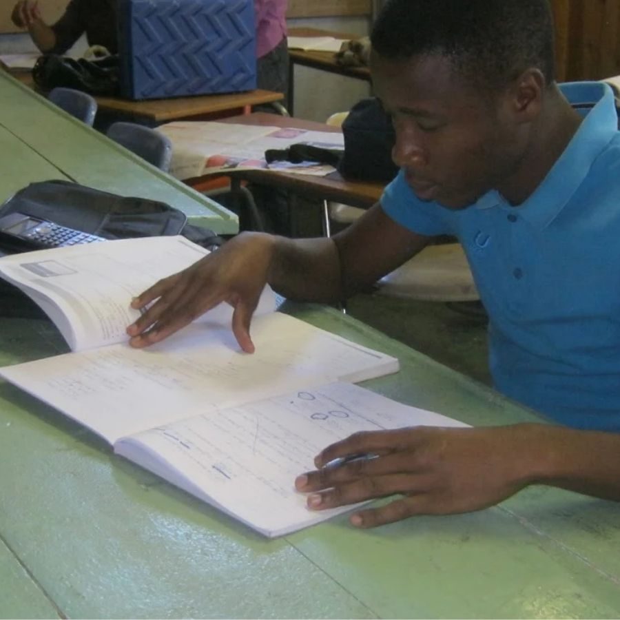 Taletso TVET College Student Studying in Class A Taletso TVET College student writes in a notebook at a classroom desk.