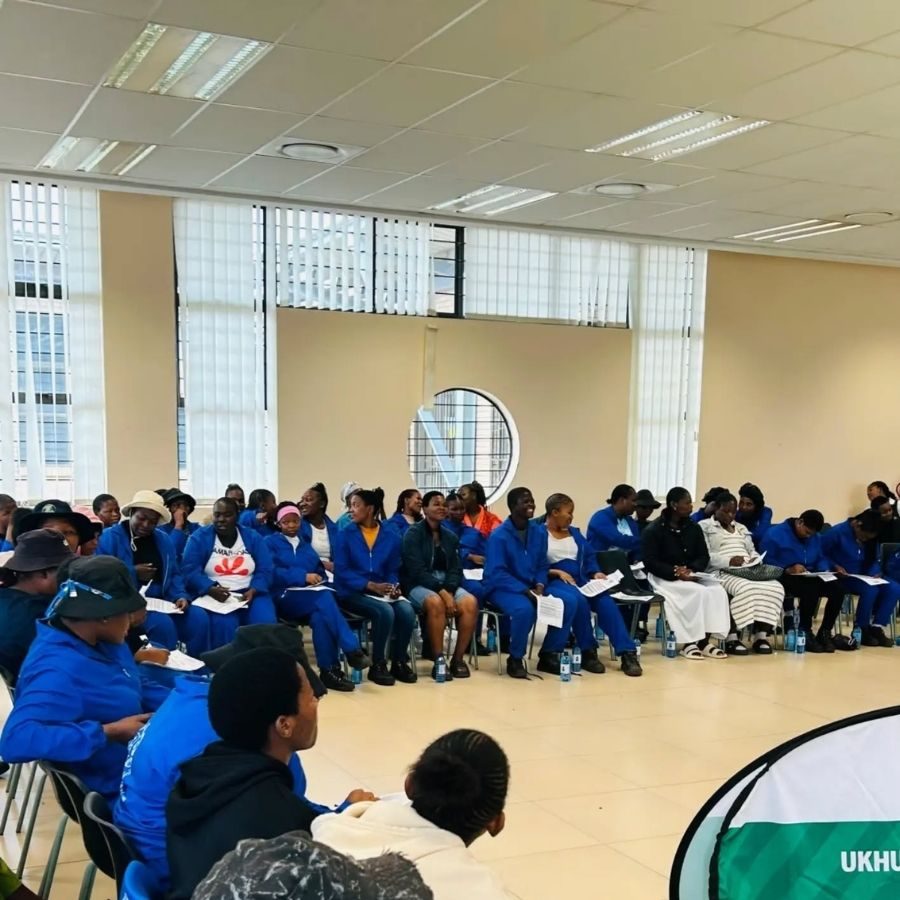 Umfolozi TVET College Students in Blue Overalls Seated Umfolozi TVET College students in blue overalls seated in rows during a training session in a large hall